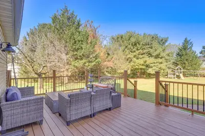 a deck with chairs and a table and a playground at 5 Mi to Princeton Family Home with Deck and Yard! in Dutch Neck