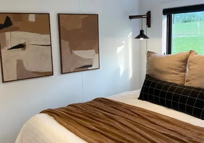 a bedroom with a bed with two pictures on the wall at Scenic Ridge Haven Firepit, Trails & Views