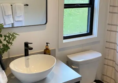 a bathroom with a white sink and a toilet at Scenic Ridge Haven Firepit, Trails & Views
