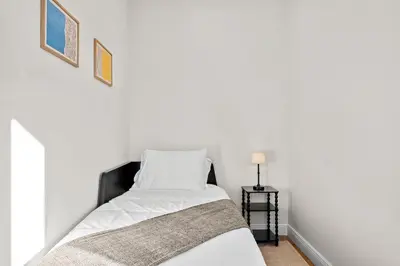a bed with white sheets and a blanket at Carroll Place - Bright 3BR Apt in Carroll Gardens in Brooklyn