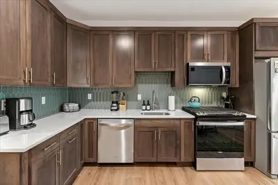 a kitchen with wooden cabinets and stainless steel appliances at Modern Princeton Stay Steps from Nassau Street in Princeton