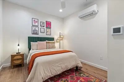 a white bedroom with a bed and a tv at Modern Princeton Stay Steps from Nassau Street in Princeton
