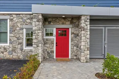 a red door on a stone house with two garage at Modern Princeton Stay Steps from Nassau Street in Princeton