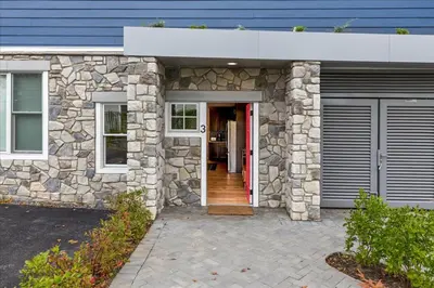 a stone house with a red door and a garage at Modern Princeton Stay Steps from Nassau Street in Princeton