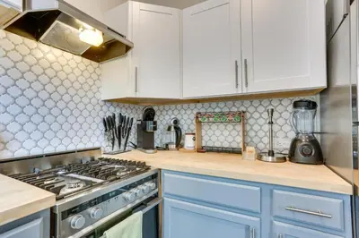 a kitchen with white cabinets and a stove top oven at Explore and Work! Stylish Washington Heights Duplex in Newburgh