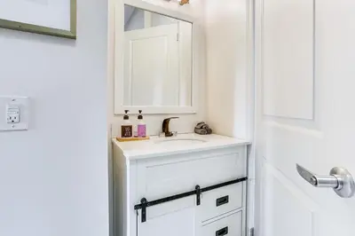 a white bathroom with a sink and a mirror at Explore and Work! Stylish Washington Heights Duplex in Newburgh