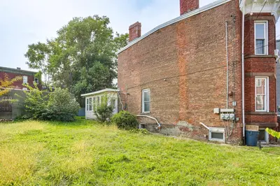 an old brick building with a grassy yard next to it at Explore and Work! Stylish Washington Heights Duplex in Newburgh