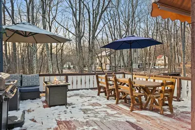 a patio with a table and chairs and umbrellas at InDoor HotTub Pocono Mountains Home