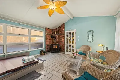 a living room with wicker chairs and a fireplace at InDoor HotTub Pocono Mountains Home
