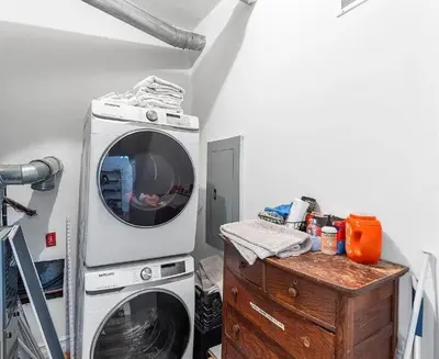 a laundry room with a washing machine and a wooden table at Charming Retreat in Trendy NoLibs in Philadelphia