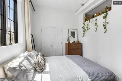 a white bedroom with a bed and a window at Charming Retreat in Trendy NoLibs in Philadelphia