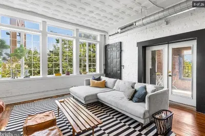 a living room with a couch and some windows at Charming Retreat in Trendy NoLibs in Philadelphia
