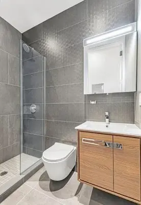 a bathroom with a toilet and a sink and a shower at Duplex Dream 4-Bedroom Bonbon in New York