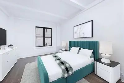 a white bedroom with a green bed and a tv at Duplex Dream 4-Bedroom Bonbon in New York