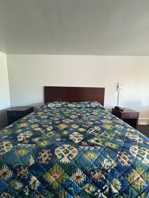 a bedroom with a bed with a colorful quilt on it at Hollywood Motel in Middletown