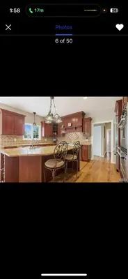 a kitchen with wooden cabinets and a table and chairs at villa in North Haledon