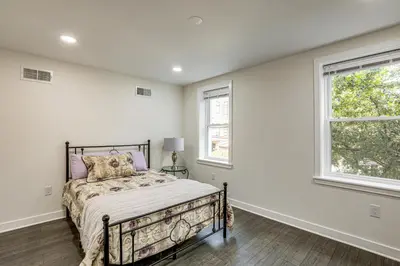 a bedroom with a bed and two windows at Updated Gem! Walk to Fishtown, 3 Mi to Center City in Philadelphia