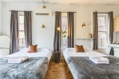 two beds in a room with windows at New Studio in Center City that Sleeps 4 with Fast Wifi in Philadelphia