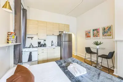 a bedroom with a bed and a kitchen with a refrigerator at New Studio in Center City that Sleeps 4 with Fast Wifi in Philadelphia