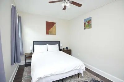 a bedroom with a white bed and a ceiling fan at Cozy Beds with Parking, Laundry - Near RU, RWJ, NJ Transit in Highland Park