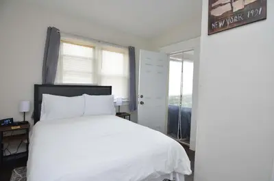 a bedroom with a white bed and a window at Cozy Beds with Parking, Laundry - Near RU, RWJ, NJ Transit in Highland Park