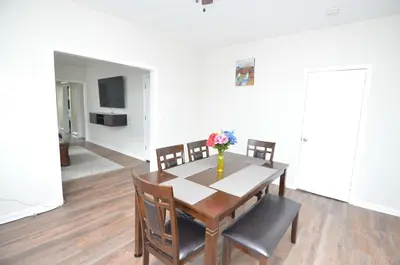a dining room table with a vase of flowers on it at Cozy Beds with Parking, Laundry - Near RU, RWJ, NJ Transit in Highland Park
