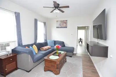 a living room with a blue couch and a tv at Spacious Home with Parking, Laundry - Near RU, RWJ, NJ Transit in Highland Park