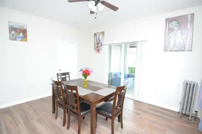a dining room table with chairs and a vase of flowers on it at Spacious Home with Parking, Laundry - Near RU, RWJ, NJ Transit in Highland Park