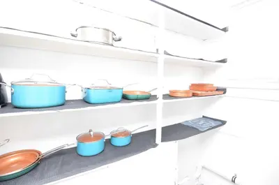 a row of pots and pans on shelves in a kitchen at Spacious Home with Parking, Laundry - Near RU, RWJ, NJ Transit in Highland Park
