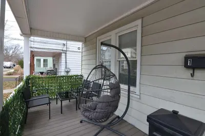 a porch with a swing and chairs on a house at Spacious Home with Parking, Laundry - Near RU, RWJ, NJ Transit in Highland Park