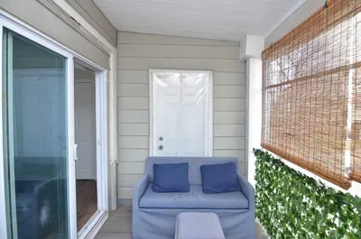 a blue couch sitting on a porch with a door at Spacious Home with Parking, Laundry - Near RU, RWJ, NJ Transit in Highland Park