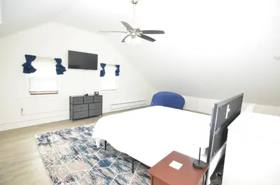 a bedroom with a bed and a desk and a tv at Cozy Beds with Parking, Laundry - Near RU, RWJ, NJ Transit in Highland Park