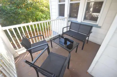 two black chairs and a table on a porch at Cozy Beds with Parking, Laundry - Near RU, RWJ, NJ Transit in Highland Park