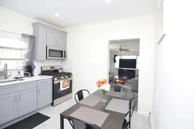 a kitchen with a table with a vase of flowers on it at Cozy Beds with Parking, Laundry - Near RU, RWJ, NJ Transit in Highland Park