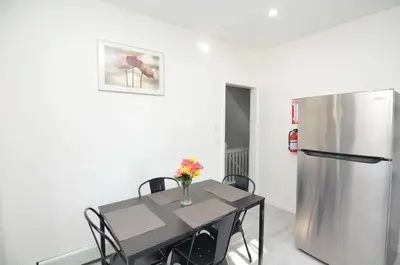 a dining room with a table and a refrigerator at Cozy Beds with Parking, Laundry - Near RU, RWJ, NJ Transit in Highland Park