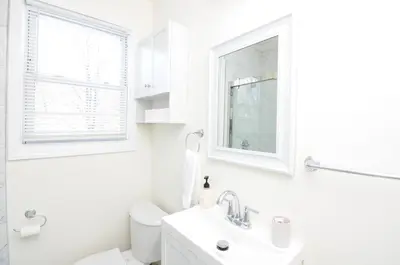a white bathroom with a sink and a window at Cozy Beds with Parking, Laundry - Near RU, RWJ, NJ Transit in Highland Park