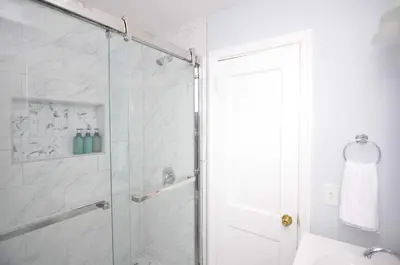 a bathroom with a shower with a glass door at Spacious Home with Parking, Laundry - Near RU, RWJ, NJ Transit in Highland Park