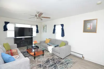 a living room with a couch and a flat screen tv at Spacious Home with Parking, Laundry - Near RU, RWJ, NJ Transit in Highland Park