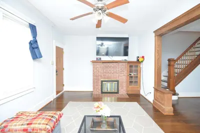 a living room with a fireplace and a ceiling fan at Cozy Beds with Parking, Laundry - Near RU, RWJ, NJ Transit in Highland Park