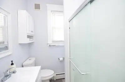 a white bathroom with a toilet and a sink at Cozy Beds with Parking, Laundry - Near RU, RWJ, NJ Transit in Highland Park
