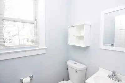 a white bathroom with a toilet and a mirror at Cozy Beds with Parking, Laundry - Near RU, RWJ, NJ Transit in Highland Park