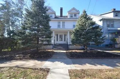a white house with two trees in front of it at Cozy Beds with Parking, Laundry - Near RU, RWJ, NJ Transit in Highland Park