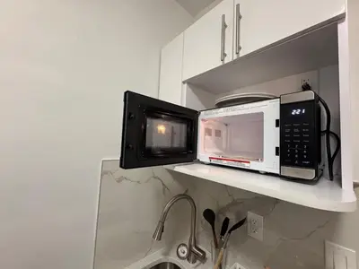 a microwave and a microwave oven on a shelf in a kitchen at Room in Chelsea 2 with Kitchen - Shared Bathroom -5th Floor Walk-UP in New York
