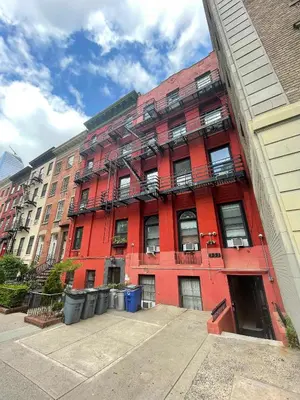 a red building with fire escapes on the side of it at Room in Chelsea 2 with Kitchen - Shared Bathroom -5th Floor Walk-UP in New York