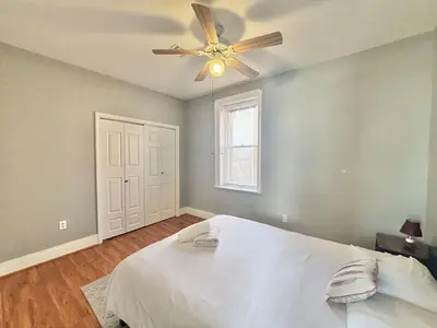 a bedroom with a white bed and a ceiling fan at FREE Parking near NYC Washer and Dryer in North Bergen