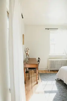 a bedroom with a table with a vase of flowers at Lady Grey Cottage - Hot Tub in Conestoga
