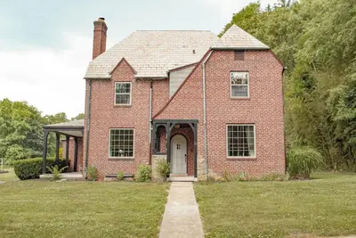 a red brick house with a white door at Lady Grey Cottage - Hot Tub in Conestoga
