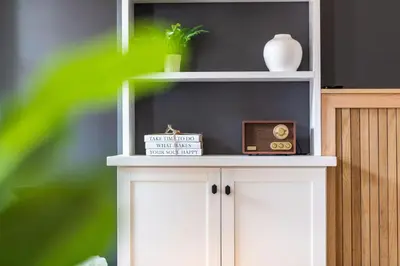 a white shelf with a clock and a vase on it at The Lancastrian House Downtown in Lancaster