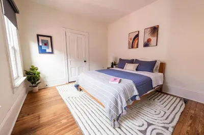 a bedroom with a bed and a rug at The Lancastrian House Downtown in Lancaster