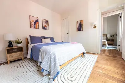 a bedroom with a bed with a blue comforter at The Lancastrian House Downtown in Lancaster